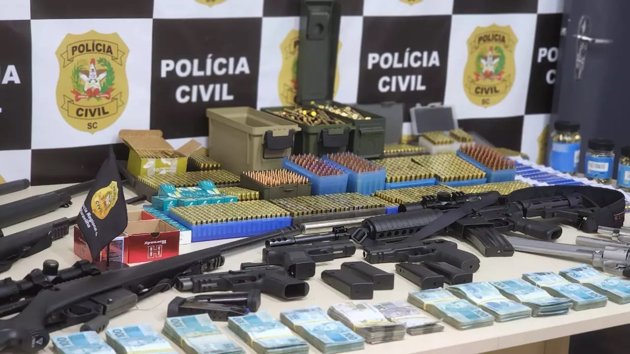 Dupla suspeita de envolvimento em bloqueio ilegal em SC é presa com 11 armas, incluindo fuzis, e R$ 125 mil